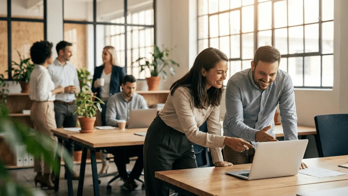 Team eines Dienstleisters bespricht im Büro Zahlen am Laptop
